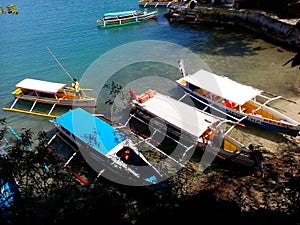 Outrigger boats beached for sightseeing stop on Governor`s Island, Hundreed Islands National Park, Alaminos, Philippinnes photo