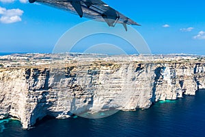 Gozo island from above, under the wing of a small plane. Aerial view of Gozo, Malta. The dome of Rotunda of Xewkija.