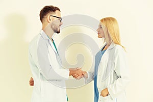 GP doctor shakes hand with surgical doctor.