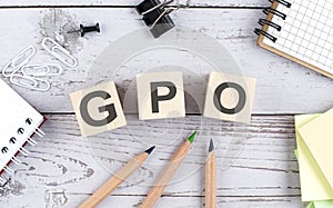 GPO - Group Purchasing Organization text on wooden block with office tools on the wooden background