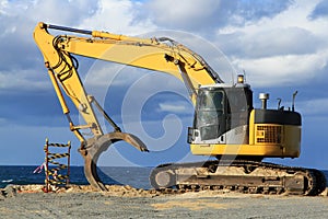 Grab excavator. Boulder wall construction.