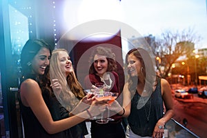 Grab your girls for a great night out. Shot of a group of young women drinking cocktails at a party.