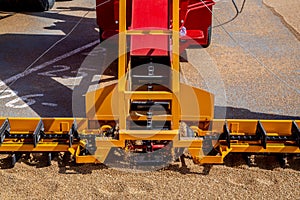 Grabbing grain from asphalt surface by scrapers of conveyor grain loader