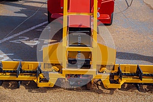 Grabbing grain from asphalt surface by scrapers of conveyor grain loader