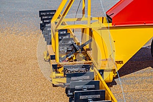 Grabbing grain from asphalt surface by scrapers of conveyor grain loader