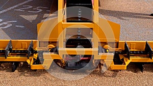 Grabbing grain from asphalt surface by scrapers of conveyor grain loader