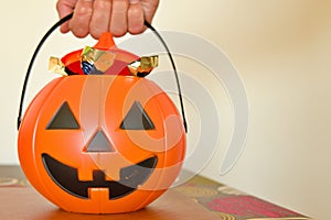 halloween pumpkin with candies, grabbing by the handle carrying candies and chocolates photo