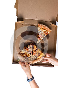 Grabbing for slices of pizza in the delivery box. Top View