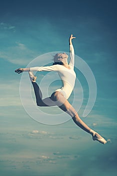 Grace in every move. Practicing art of classical ballet. Ballerina jumping on blue sky. Cute ballet dancer. Pretty woman