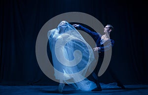 Graceful balerina in image of ghost bride with patner in art ballet performance isolated over dark background. photo