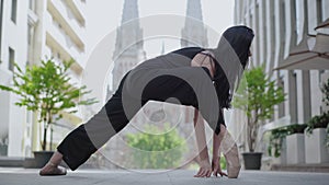 Graceful ballerina in ballet position with ancient European city at the background. Portrait of charming gorgeous