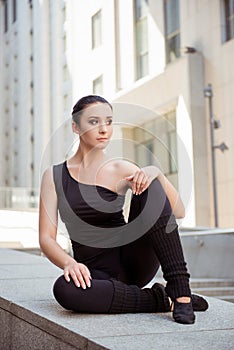 Graceful ballerina sitting on the balusters