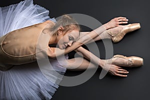 Graceful ballerina sitting on the floor