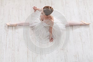 Graceful ballerina stretching, ballet background