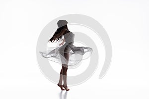 Graceful ballerina in white dress dancing on white background