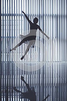 Graceful ballet dancer jumping near the window