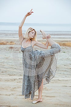 Graceful beautiful young woman dancer on the beach