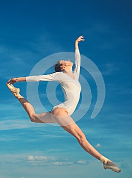 Graceful beauty. Concert performance dance. Young ballerina jumping on blue sky. Classic dance style. Cute ballet dancer