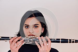 Graceful Brunette Musician Posing with Clarinet on White Background