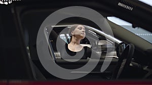 Graceful caucasian ballerina dancing in car dealership. Portrait of young professional ballet dancer making classic