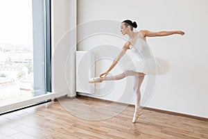 Graceful classical female dancer stretching her legs.