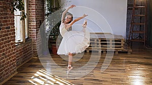 Graceful dance ballerina practicing exercise classical ballet in sport school. Flexibility exercise training. Young