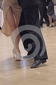 Graceful dance couple tangoing at the ballroom.