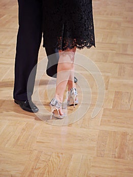 Graceful dance couple tangoing at the ballroom.