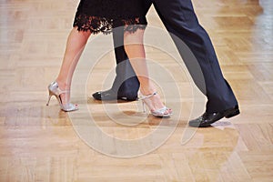 Graceful dance couple tangoing at the ballroom.