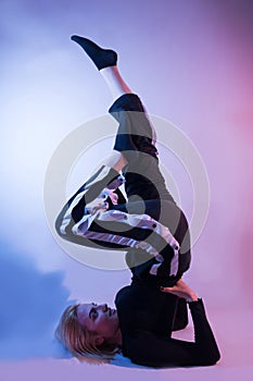 Graceful Elegance: Young Woman Showcasing Gymnastic Skills in Vibrant Ambiance