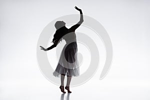 Graceful, elegant ballerina in white dress dancing