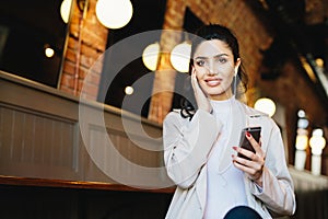 Graceful female with dark hair and eyes sitting in cafe using fr