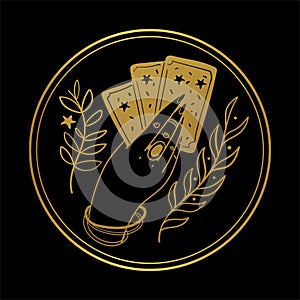 Graceful female hand of a gypsy woman holds tarot cards. Round gold icon on a black background. The concept of