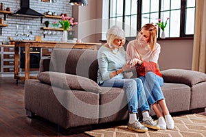 Graceful retired female looking at granddaughter wedding ring