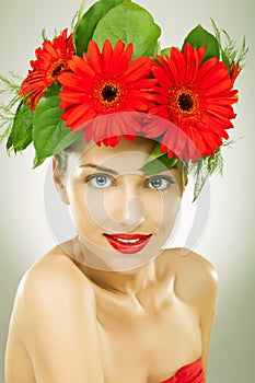 Gracefull young woman with red flowers in her hair