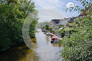 Gracht or canal with boats and shore gardens in Friedrichstadt, the beautiful town and travel destination in northern Germany