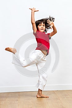 Gracious beautiful young girl dancing, showing joyous dynamic child movement photo
