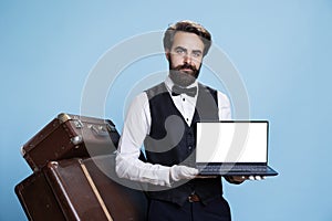 Gracious bellboy holds laptop