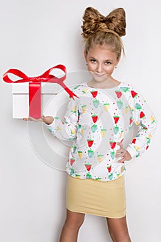 Gracious little girl with blond hair and blue eyes standing on a white background wearing a sweatshirt