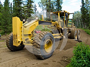 Grader resurfacing narrow rural road
