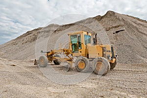 Grader for road construction in a gravel pit