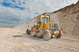 Grader for road construction in a gravel pit