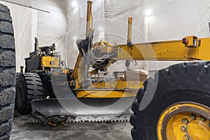 The grader is serviced in an industrial garage. photo