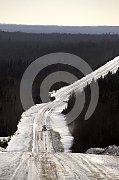 Grader at work on logging road in winter