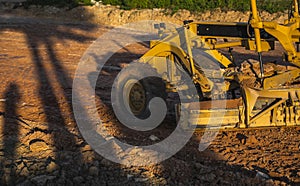 Grader is working on road construction. Grader industrial machine on construction of new roads. Heavy duty machinery