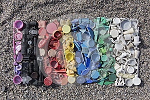 Gradient color of plastic parts, degraded still life of plastic caps and different plastic pieces found on the beach, aerial view