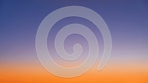 Gradient of orange-blue evening sky without clouds at sunset