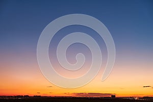 Gradient of orange-blue evening sky without clouds at sunset