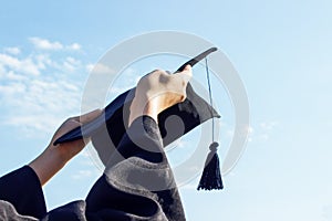 Graduate celebrating with cap in her hand,feeling so proud and happiness in Commencement day