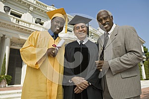Graduate with dean and father outside university photo